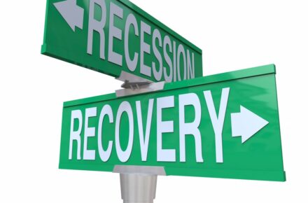 A recession and a recovery sign pointing in opposite directions