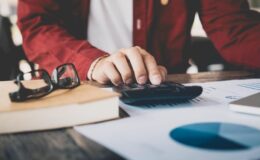 An accountant with a calculator and some charts.