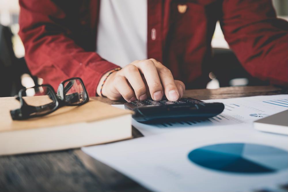 An accountant with a calculator and some charts.