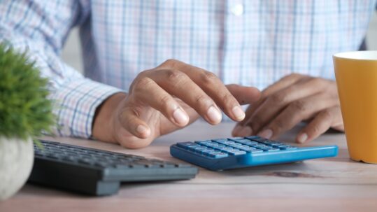 Man typing on calculator